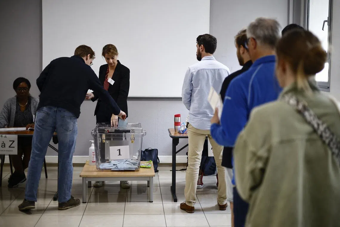 FILE PHOTO: People queue to vote in the second round of the early French parliamentary elections, at a polling station in Paris, France, July 7, 2024. REUTERS/Yara Nardi/File Photo