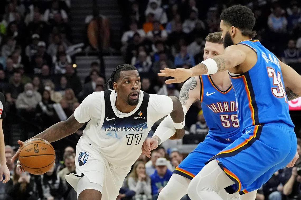 Minnesota Timberwolves centre Naz Reid dribbles around Oklahoma City Thunder centre Isaiah Hartenstein and guard Kenrich Williams in the fourth quarter at Target Centre.