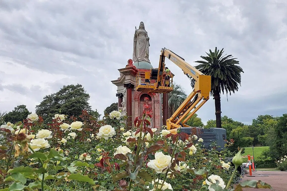 A council worker cleans the statue of Britain's Queen Victoria that was defaced in the Royal Botanic Gardens Victoria in Melbourne on Jan 25, ahead of Australia Day.