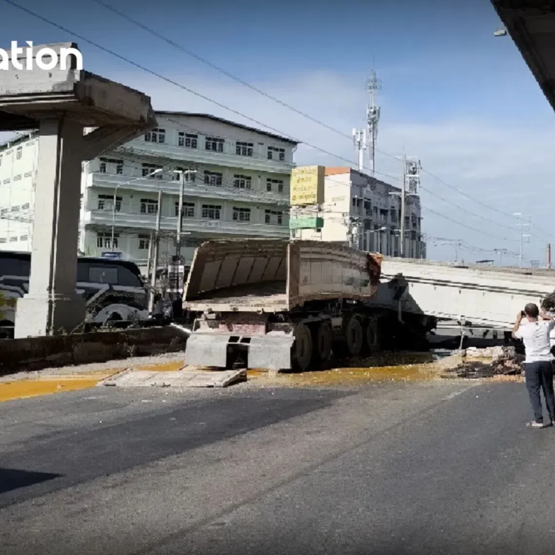 An 18-wheel dump truck had raised its bed while driving before colliding with the overpass structure.