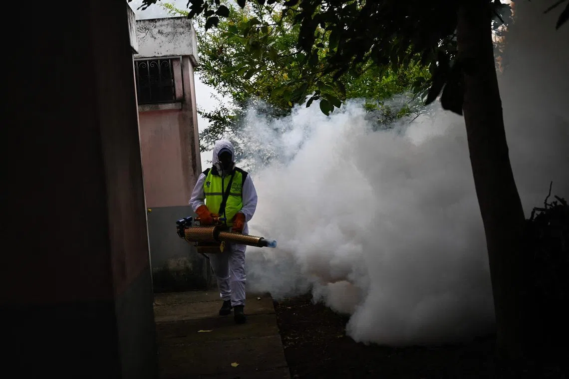 A municipal worker fumigates against the Aedes aegypti mosquito, a vector of the dengue, Zika, and Chikungunya viruses, as a preventive measure outside Las Misericordias Church in Guatemala City on Aug 30, 2023.  