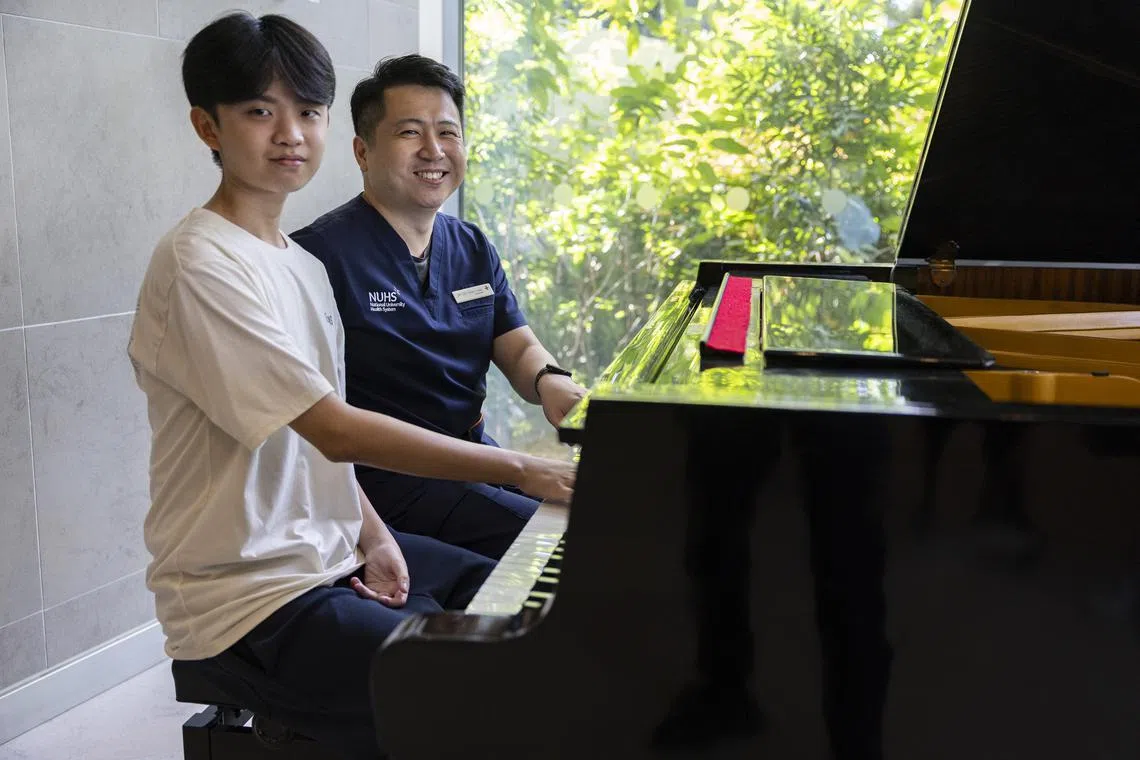 Ryan Lim (left) from Ahmad Ibrahim Secondary School, and his doctor Dr Lee Yang Yang playing the piano at the NUHS Tower Block on Aug 25.