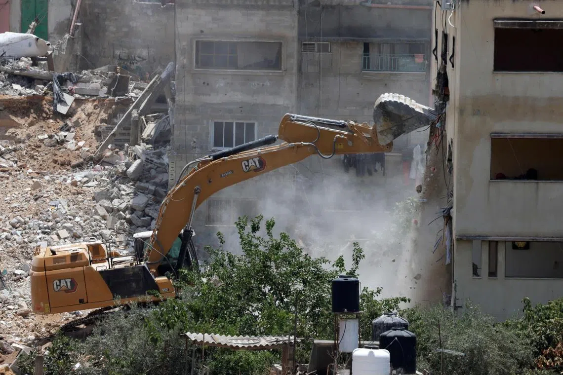 An Israeli military bulldozer demolishing a home at the Nur Shams Palestinian refugee camp, east of Tulkarem, in the Israeli-occupied West Bank on June 23. 