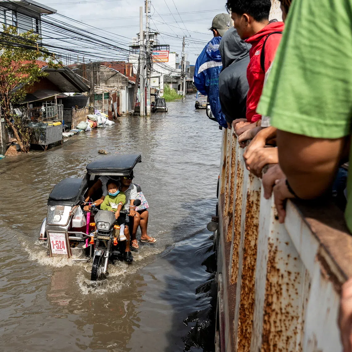 People ride a motorbike with a sidecar as it wades through a flooded road following flooding brought by high tide and Super Typhoon Fung-wong, in Macabebe town, Pampanga province, Philippines, 