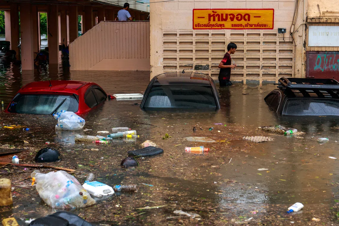 Submerged cars on a flooded street during heavy rain in Bangkok, on Sept 26.
