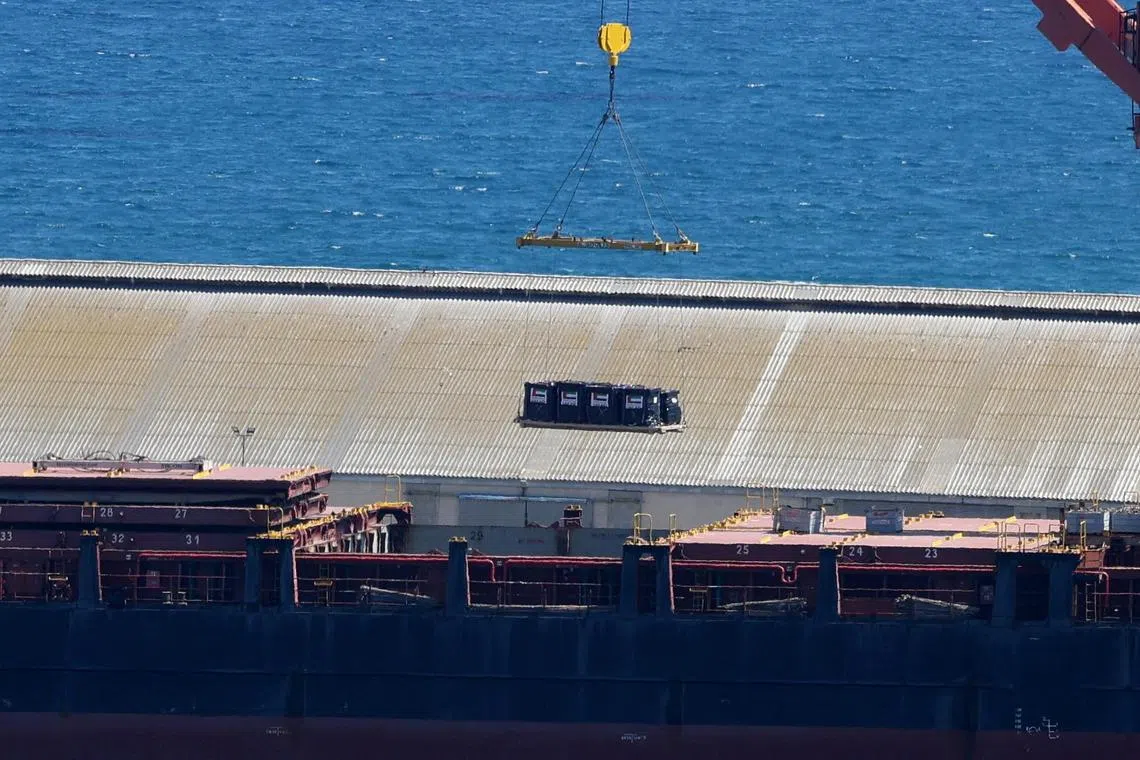 A crane lifts cargo with UAE flags onto a cargo vessel expected to take aid to Gaza from Cyprus at the port of Larnaca on May 8.