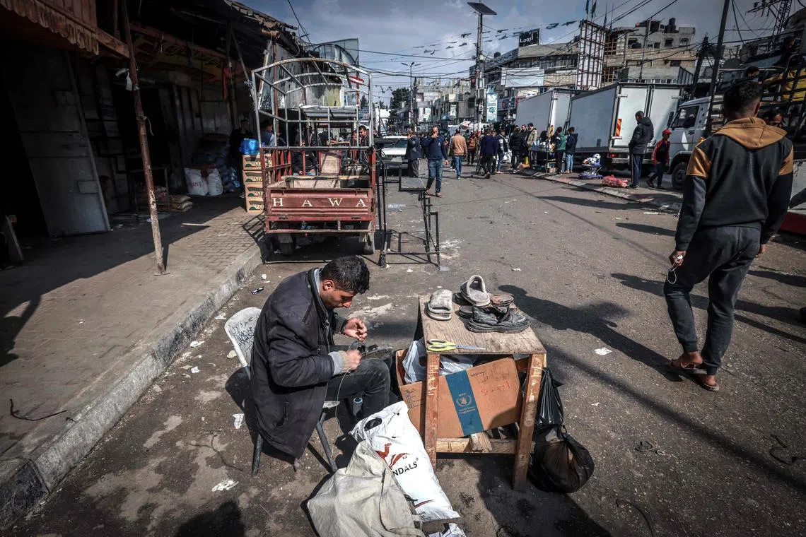 A Palestinian man fixing shoes in a main street in Rafah, in the southern Gaza Strip, on Feb 19, 2024.