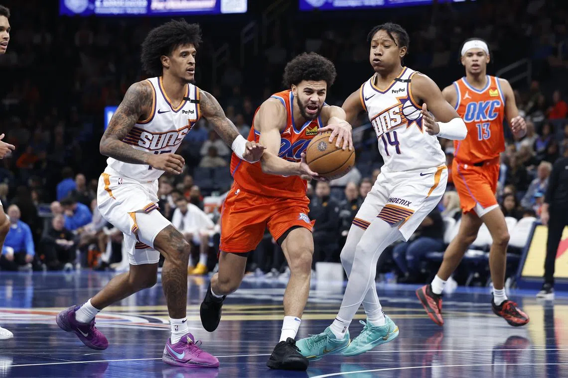 FILE PHOTO: Nov 15, 2024; Oklahoma City, Oklahoma, USA; Oklahoma City Thunder guard Ajay Mitchell (25) drives to the basket between Phoenix Suns forward Jalen Bridges (15) and guard TyTy Washington Jr. (14)during the fourth quarter at Paycom Center. Alonzo Adams-Imagn Images/File Photo