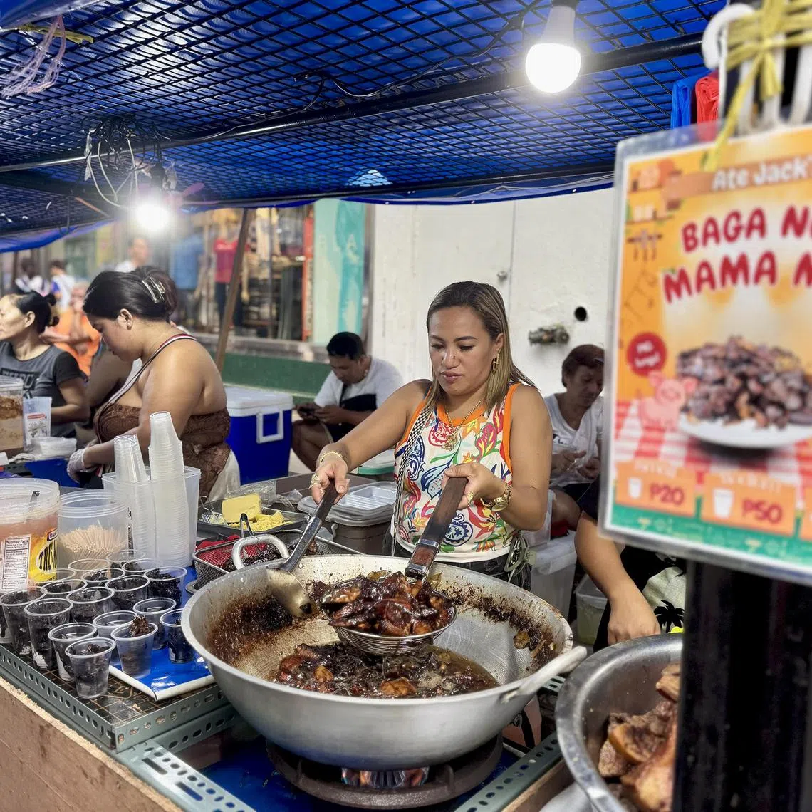 Street vendor Jacklyn Alfaro on July 31, 2025 cooks a fresh batch of fried pork lungs, the delicacy that made her stall famous along Carriedo Street in Manila, Philippines. 