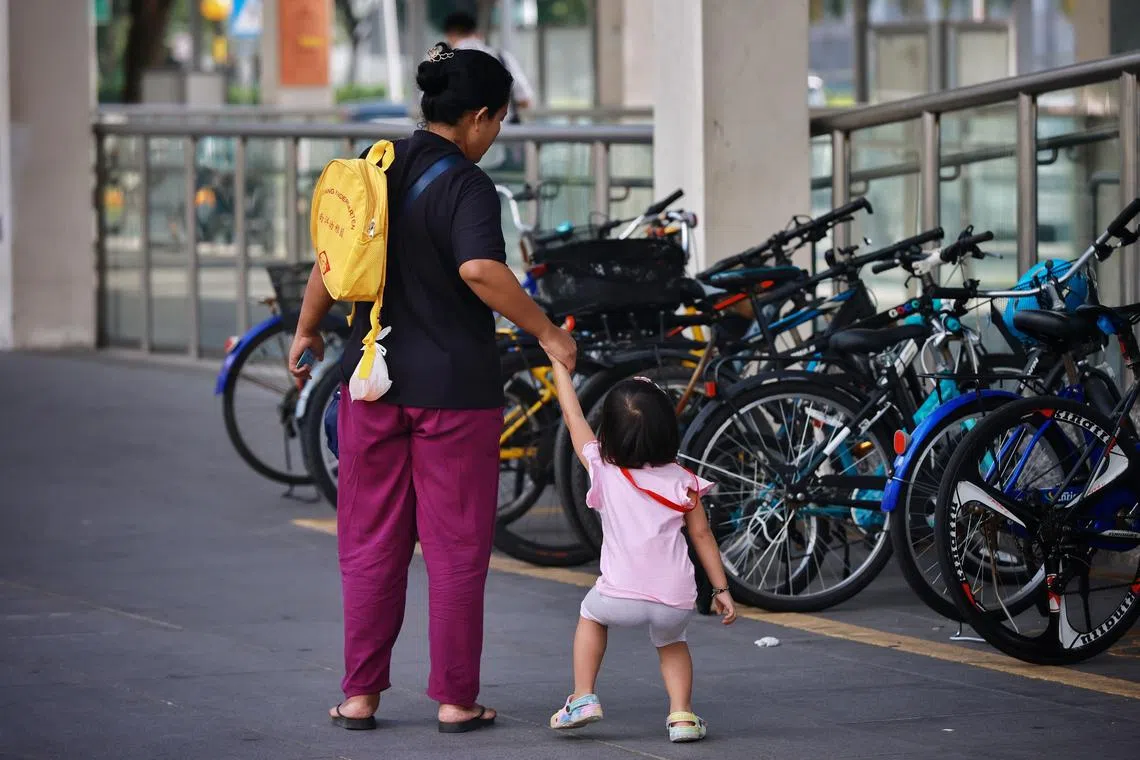 A domestic helper with a child outside Hillion mall on Feb 16, 2023.