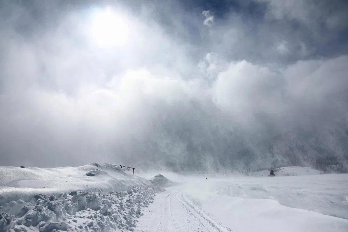 Snow is blown by strong winds as storm clouds pass, with snow continuing to fall in the Sierra Nevada mountains in the wake of an atmospheric river event, on March 11, 2023, in Mammoth Lakes, California. 