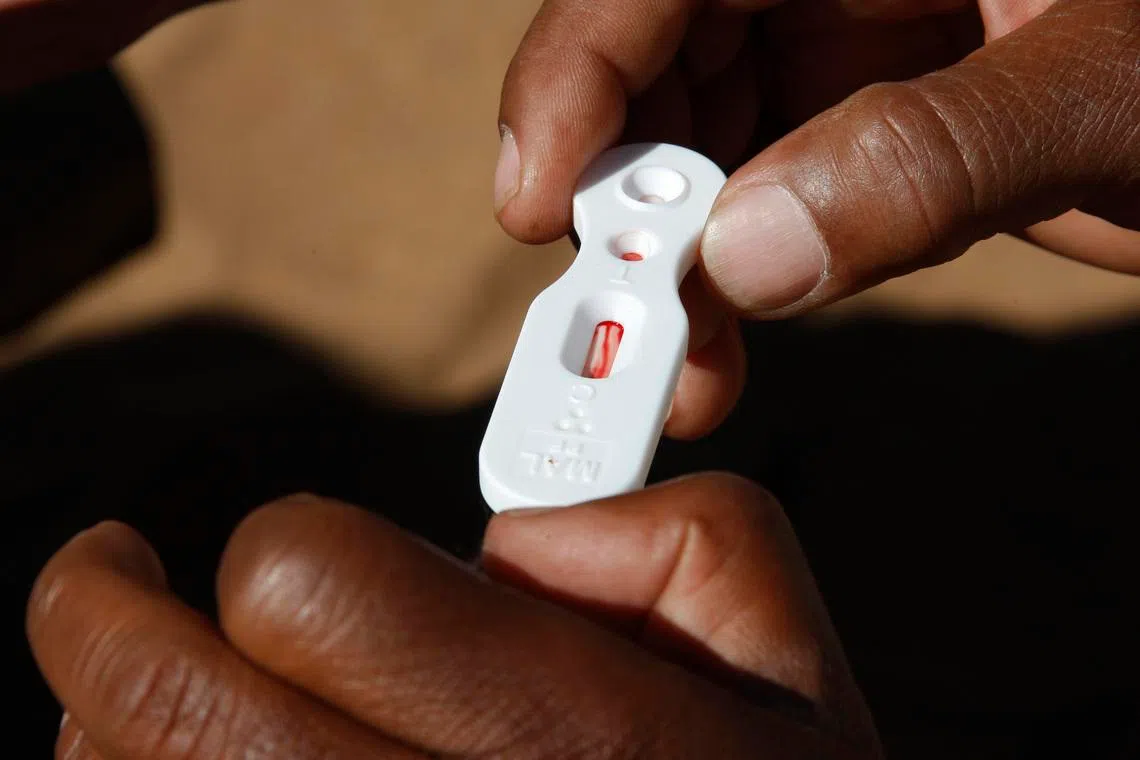 FILE PHOTO: A Zambian healthcare worker checks a malaria test in this file photo in Matongo village, April 23, 2008. REUTERS/Thierry Roge (ZAMBIA)/File Photo