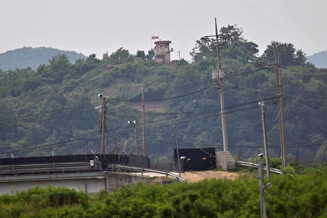 A North Korean guard post (top) on the North side of the Demilitarised Zone (DMZ) is seen over a South Korean military fence (bottom) from the border city of Paju.