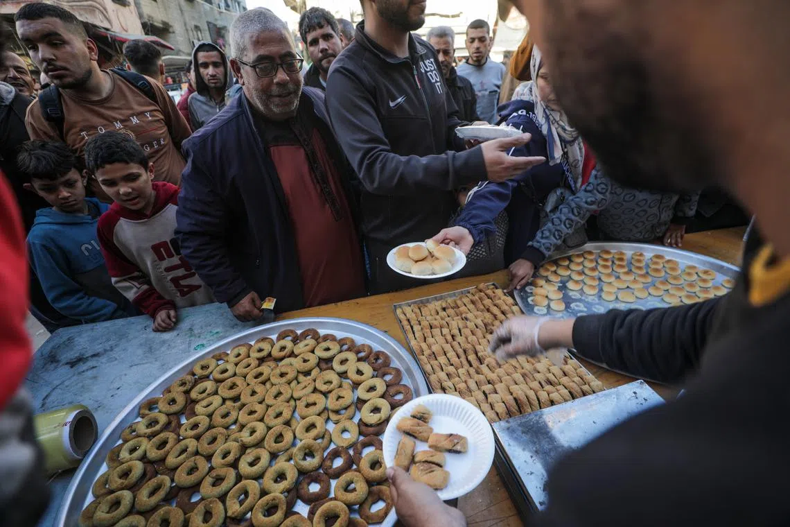 Palestinians selling sweets on a street on the first day of Ramadan, in Al Nusairat refugee camp, Gaza Strip, on Mar 11, 2024. 