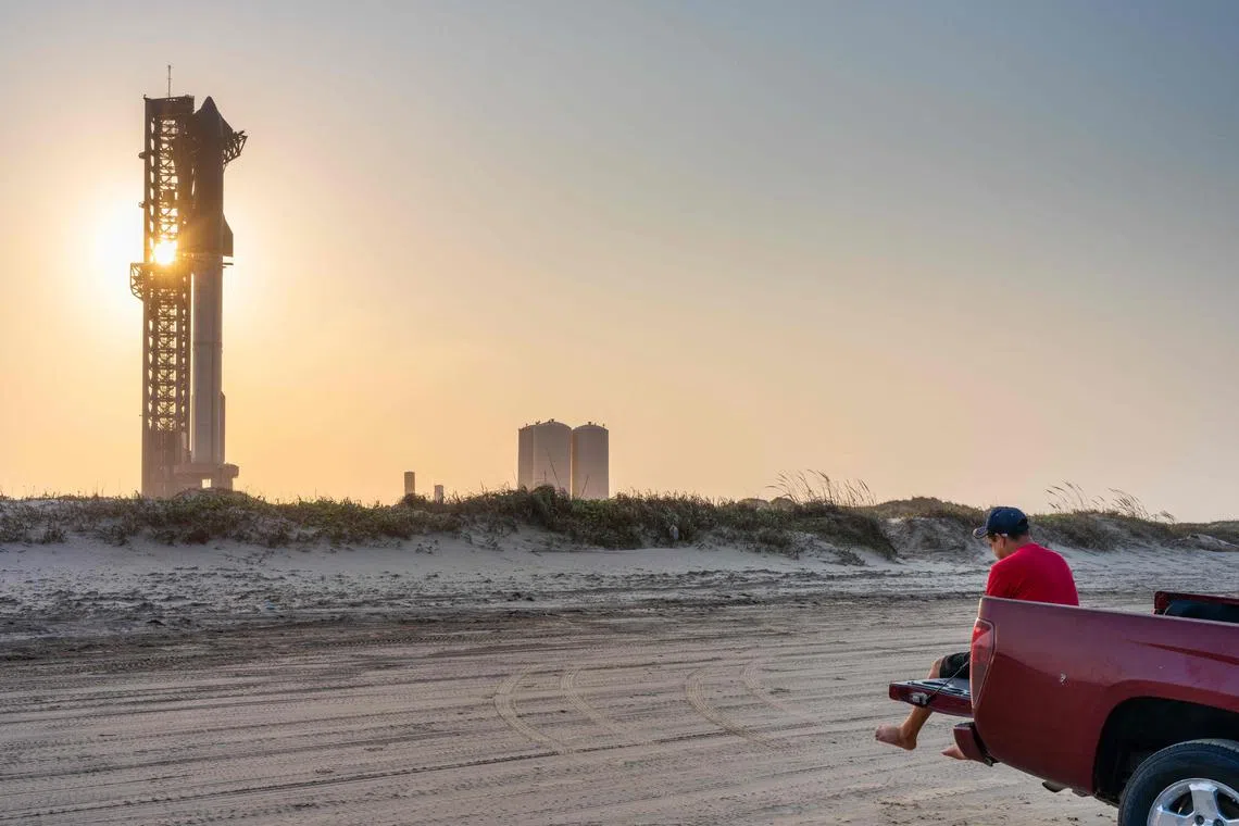 BROWNSVILLE, TEXAS - JUNE 05: A person sits out the back of their pickup truck as the sun sets behind the SpaceX Starship ahead of its fourth flight test at Boca Chica beach on June 05, 2024 in Brownsville, Texas. With each launch, and a focus of various objectives, the Starship remains the world's most powerful launch vehicle ever created. During the fourth flight test, SpaceX will continue its ongoing assessments with a focus on “demonstrating the ability to return and reuse Starship and Super Heavy..." The company says that the "primary objectives will be executing a landing burn and soft splashdown in the Gulf of Mexico with the Super Heavy booster, and achieving a controlled entry of Starship,” according to a news release.   Brandon Bell/Getty Images/AFP (Photo by Brandon Bell / GETTY IMAGES NORTH AMERICA / Getty Images via AFP)
