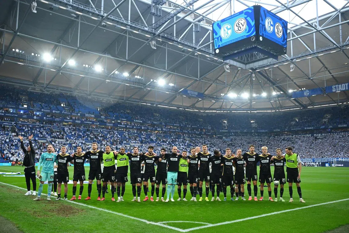 Soccer Football - 2. Bundesliga - Schalke 04 v SV Elversberg - Veltins-Arena, Gelsenkirchen, Germany - May 18, 2025 SV Elversberg players celebrate in front of the fans after qualifying for the Bundesliga promotion play-offs. REUTERS/Annegret Hilse