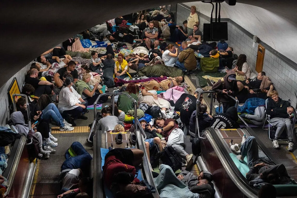 TOPSHOT - People take shelter at a metro station during Russian missile strike on Kyiv, early on July 30, 2026, amid the Russian invasion of Ukraine. Russian strikes on Kyiv killed at least one person, authorities said on July 30, after Ukrainian President Volodymyr Zelensky warned of Moscow launching another massive attack overnight. (Photo by OLEKSII FILIPPOV / AFP)