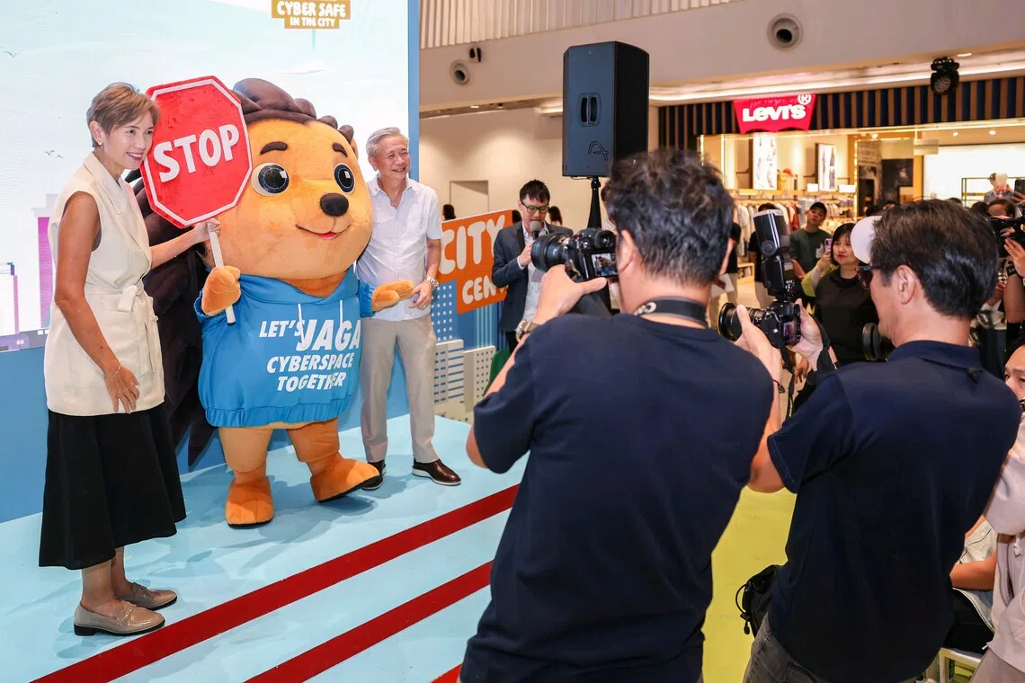 Minister for Digital Development and Information Josephine Teo and Cyber Security Agency of Singapore chief executive David Koh taking a photo with cybersecurity mascot Jaga at the Cyber Safe in the City roadshow on Sept 13.