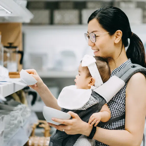 Asian mum shopping with baby in baby carrier