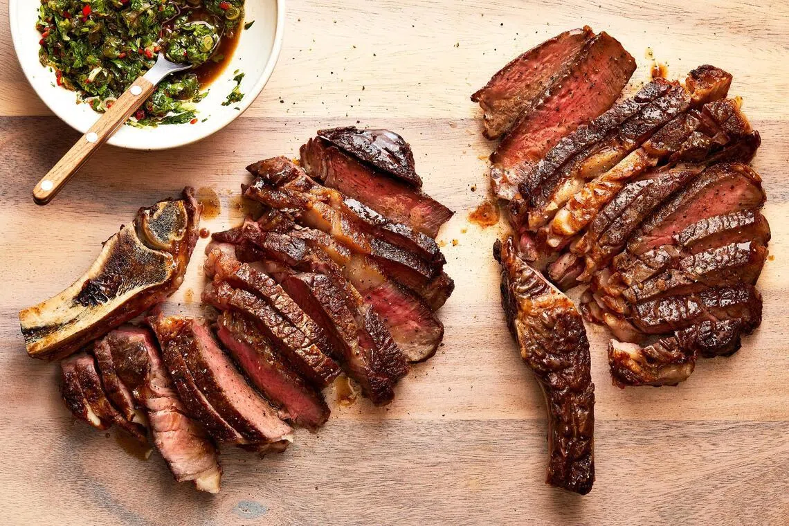Seared bone-in rib-eye steaks.