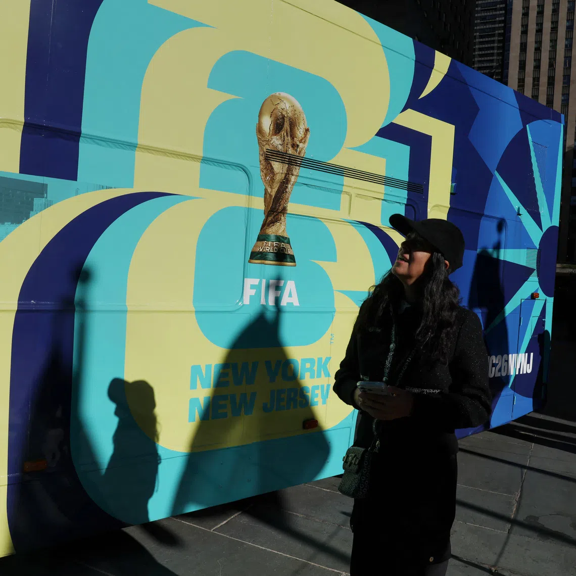 A woman walks by a bus advertisement for FIFA World Cup 26 New York and New Jersey at Rockefeller Center in New York City, U.S., October 23, 2025. REUTERS/Shannon Stapleton