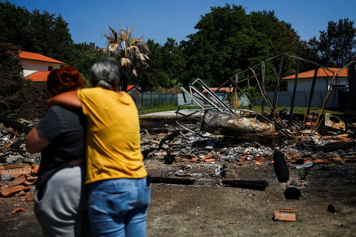 Beatrice Dubaquier, 49, hugs her daughter Lucie Blanc Dubaquier, 24 in front of their burnt home near a forest affected by a wildfire, in Biscarrosse, Landes department, amid drought conditions, a new heatwave warning, and water shortages across much of France, July 28, 2026. REUTERS/Sarah Meyssonnier