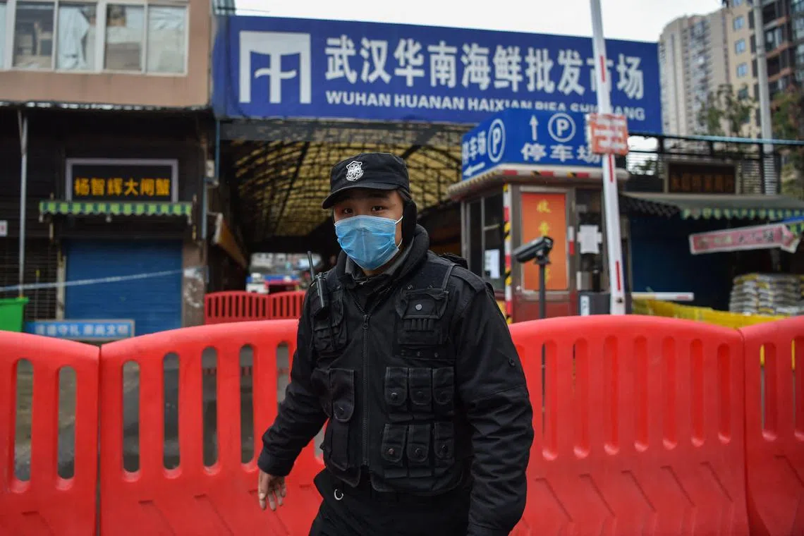 (FILES) In this file photo taken on January 24, 2020, a police officer stands guard outside the Huanan Seafood Wholesale Market where the coronavirus was detected in Wuhan. - Residents in Wuhan are marking three years since a once-mysterious virus plunged them into a terrifying lockdown, with their city becoming the epicentre of the Covid-19 epidemic that became global. (Photo by Hector RETAMAL / AFP)