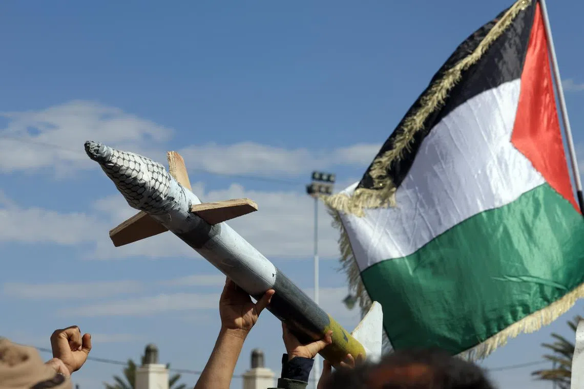 Houthi supporters hold up a mock missile and wave a Palestinian flag during a protest in Sanaa, Yemen, March 17 2025 against US airstrikes on Houthi positions. 