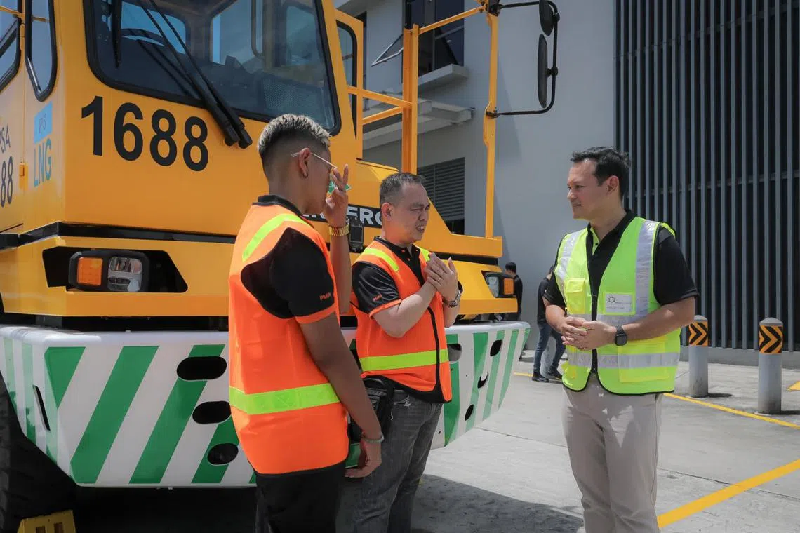 Senior Minister of State for Manpower Zaqy Mohamad (right) speaking to prime mover operators at the Pasir Panjang Terminal.