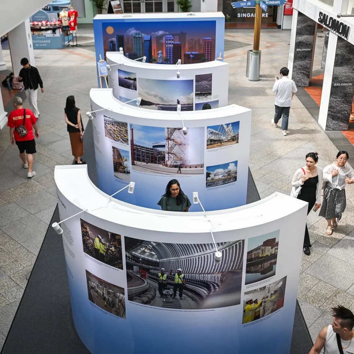 People viewing the Invisible Power. Visible Impact photo exhibition, which opened at Bugis Junction on Jan 19, 2026.