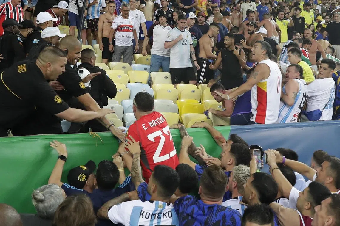 Argentina goalkeeper Emiliano Martinez tries to control a clash between fans that broke out before their World Cup qualifier with Brazil in Rio de Janeiro.