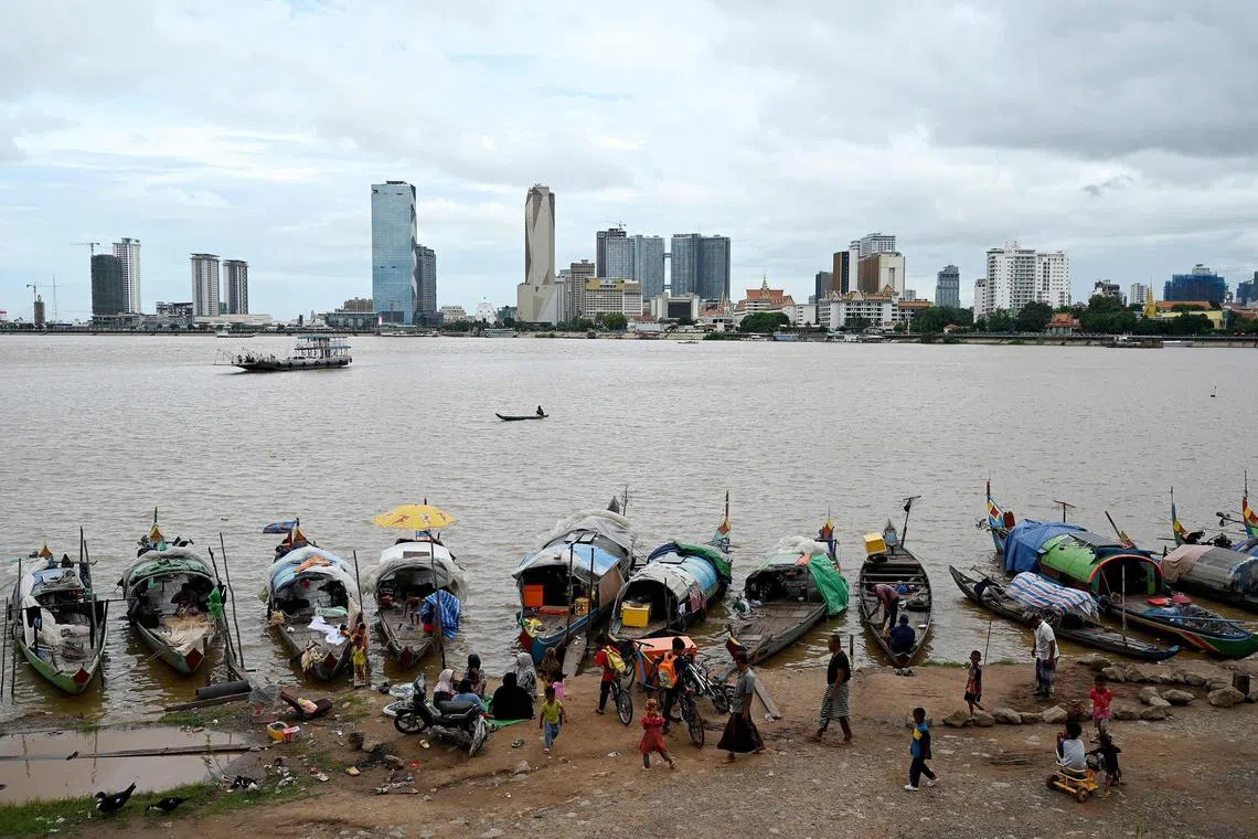 Members of the Cham minority Muslim community gather by the banks of the Mekong river in Phnom Penh on September 4, 2023. (Photo by TANG CHHIN Sothy / AFP)