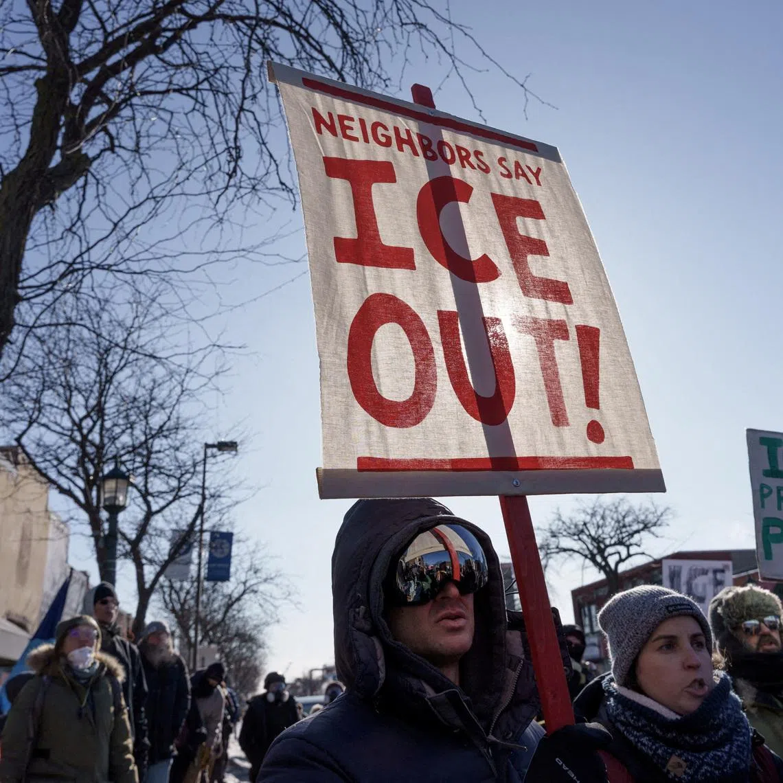 FILE PHOTO: Demonstrators carry signs condemning Immigration and Customs Enforcement (ICE) near the site where a man identified as Alex Pretti was fatally shot by federal agents trying to detain him, in Minneapolis, Minnesota, U.S., January 24, 2026. REUTERS/Tim Evans/File Photo