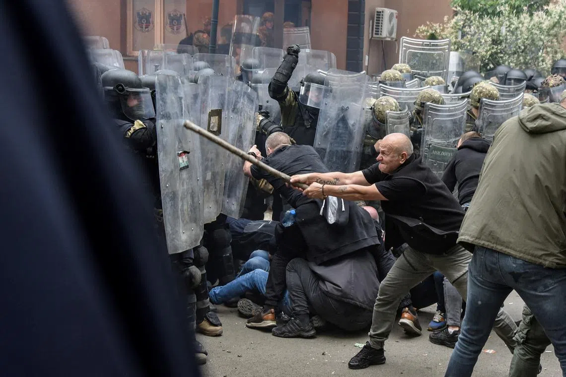 Nato Kosovo Force (KFOR) soldiers clash with local Kosovo Serb protesters at the entrance of the municipality office.