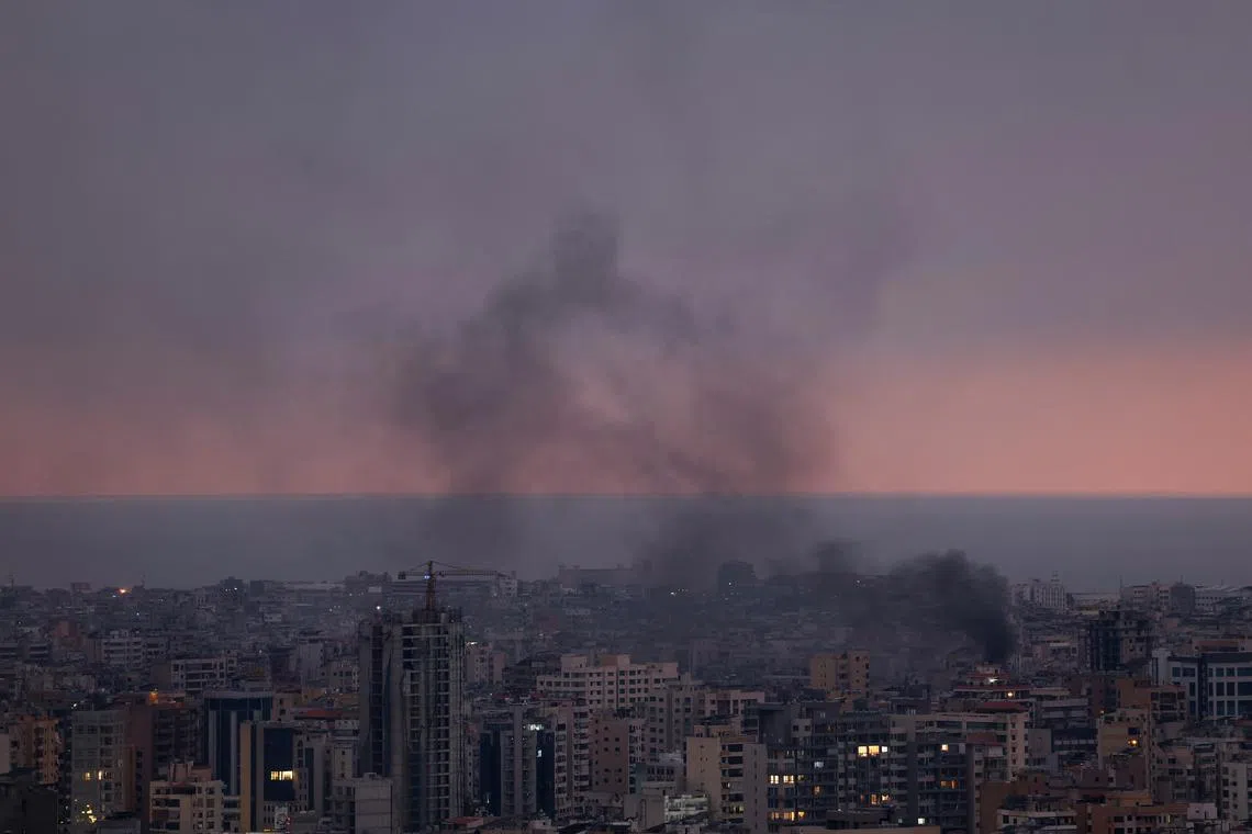 Smoke rises in Beirut's southern suburbs during sunset, after Israeli air strikes.