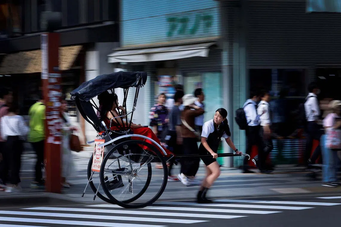 Rickshaw puller Akina Suzuki, 19, drives a rickshaw around Asakusa district in Tokyo, Japan, June 18, 2023. Pullers walk or run an average of 20 km (12 miles) a day and, in addition to being physically strong, they must have extensive knowledge of Tokyo and know how to engage with the tourists, who mostly hire them for sightseeing, with the most popular drivers make over 1 million yen a month, three times the national average. REUTERS/Issei Kato SEARCH "KATO RICKSHAW" FOR THIS STORY. SEARCH "WIDER IMAGE" FOR ALL STORIES. TPX IMAGES OF THE DAY