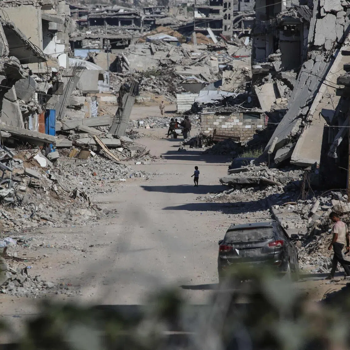 Palestinians making their way through destroyed buildings in Khan Yunis, in the southern Gaza Strip, on July 31.