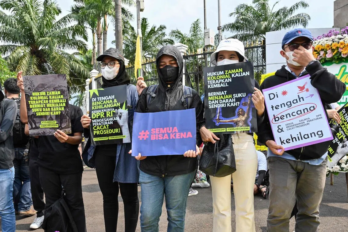 This picture taken on Dec 5, 2022 shows activists holding a protest against the new criminal code outside the Parliament building in Jakarta. 