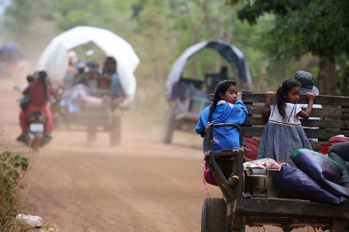 Girls sit behind a tractor on the way to a refugee camp as they are evacuated amid deadly clashes between Thailand and Cambodia along a disputed border area, in Chong Kal, Oddar Meanchey Province, Cambodia, December 10, 2025.   REUTERS/Kim Hong-ji