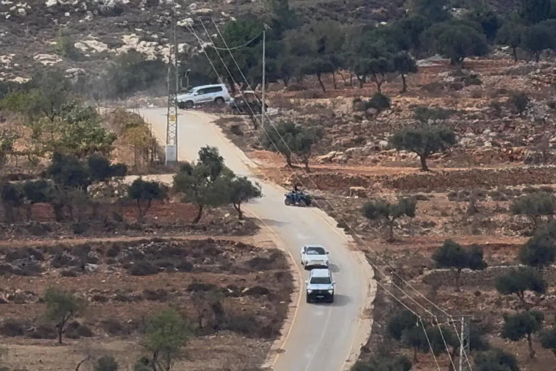 Vehicles drive at the site where Belgium’s foreign minister says masked settlers in the Israeli-occupied West Bank attacked Palestinians, Catholic representatives and Western diplomats and officials.