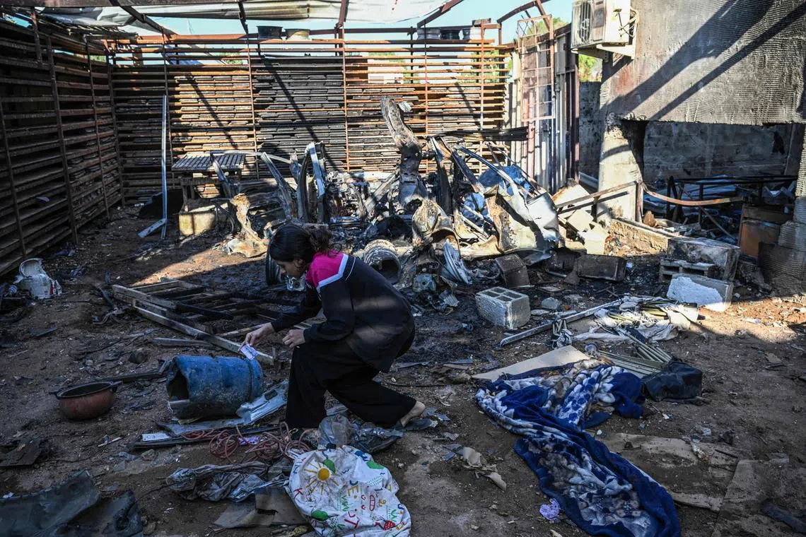 A Palestinian girl searches for personal items at a backyard of a home in Jenin raided by the Israeli army.