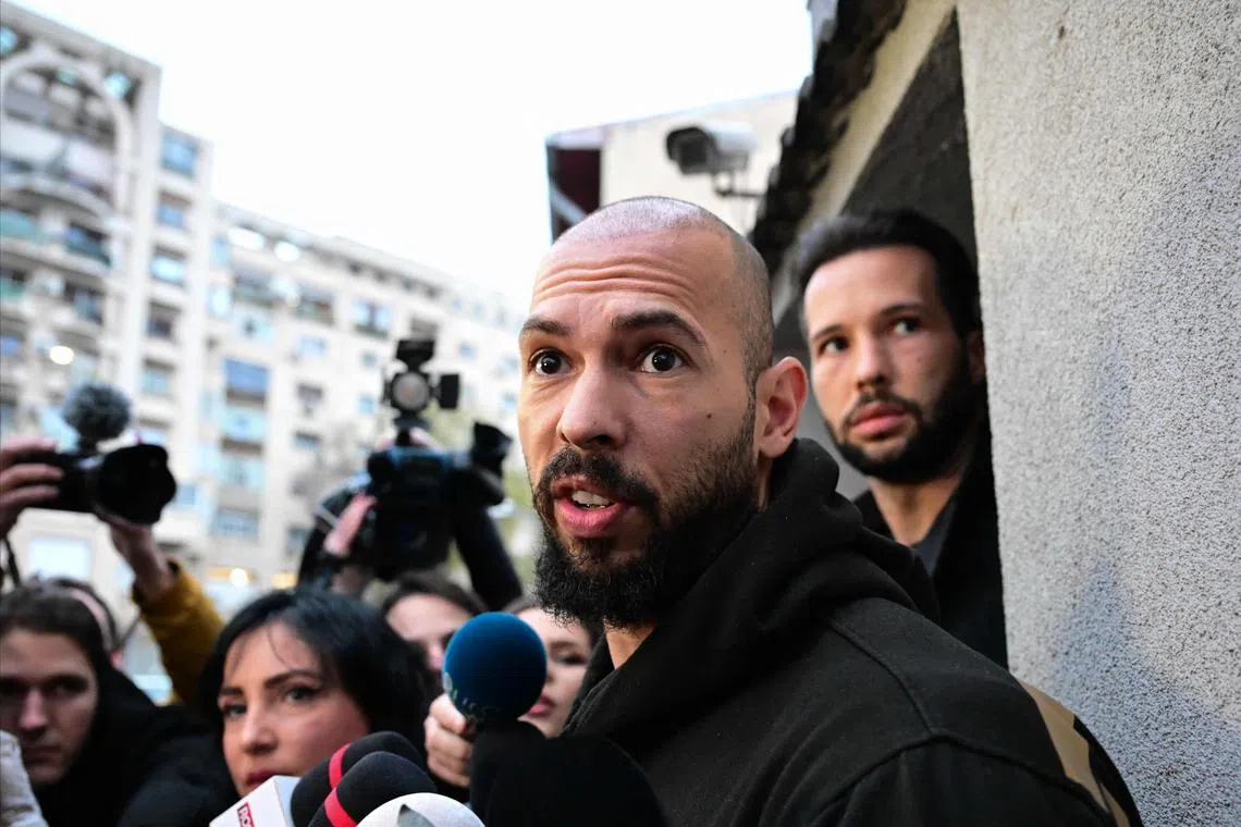 A 2024 photo shows Andrew Tate (centre) and his brother Tristan Tate (right) speaking to journalists in Bucharest, Romania.