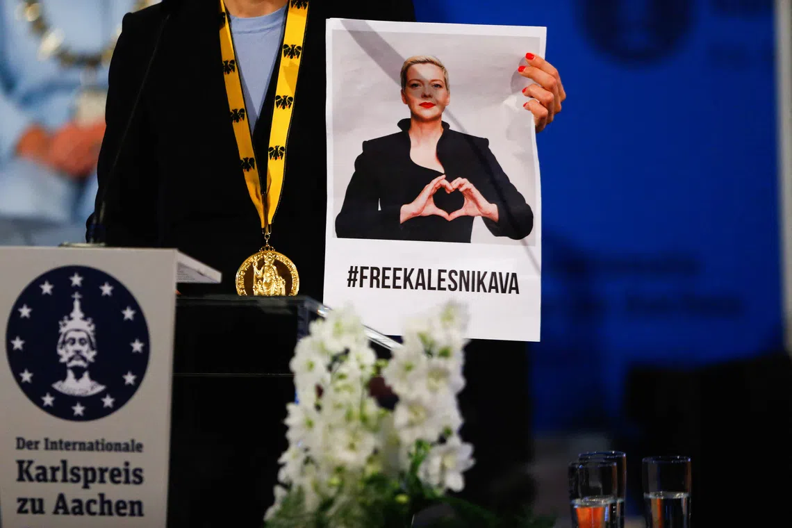 FILE PHOTO: Tatsiana Khomich holds up a picture of her detained sister Maria Kalesnikava as she gives a speech after accepting the Charlemagne Prize on her behalf, during a ceremony in Aachen, Germany, May 26, 2022. REUTERS/Thilo Schmuelgen/File Photo