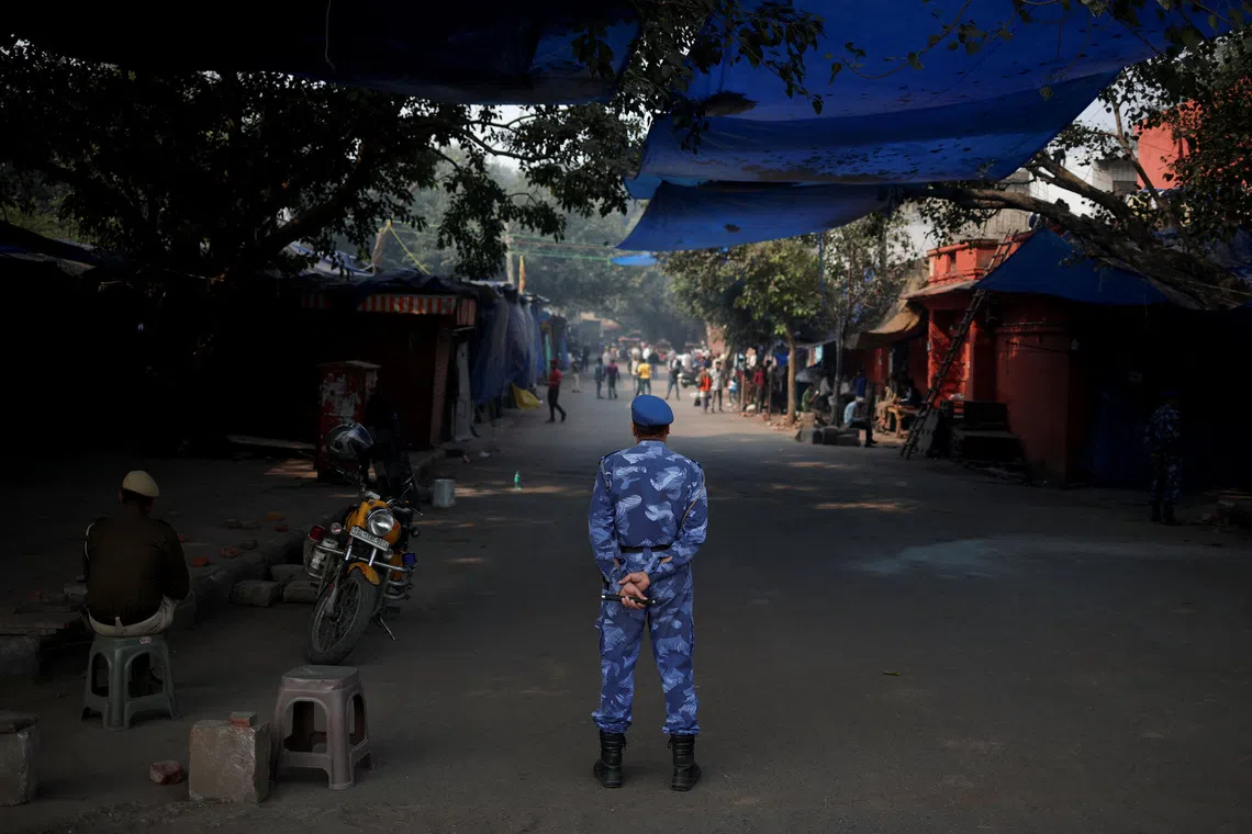 A security personnel stands guard at a closed market area near the site of an explosion, near the historic Red Fort in the old quarters of Delhi, India, November 12, 2025. REUTERS/Adnan Abidi