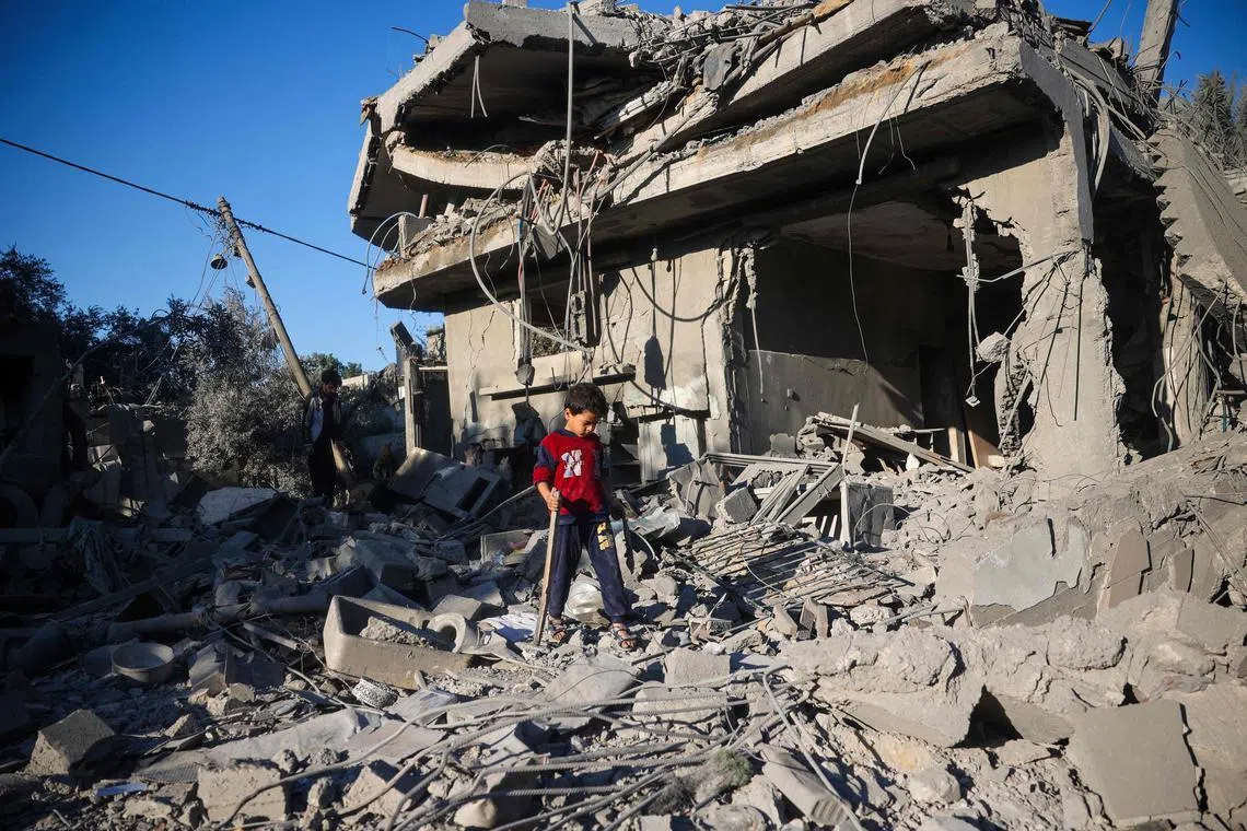 A boy walks on the rubble of a house destroyed in an Israeli strike at the Nuseirat refugee camp, central Gaza Strip, on Nov 12.