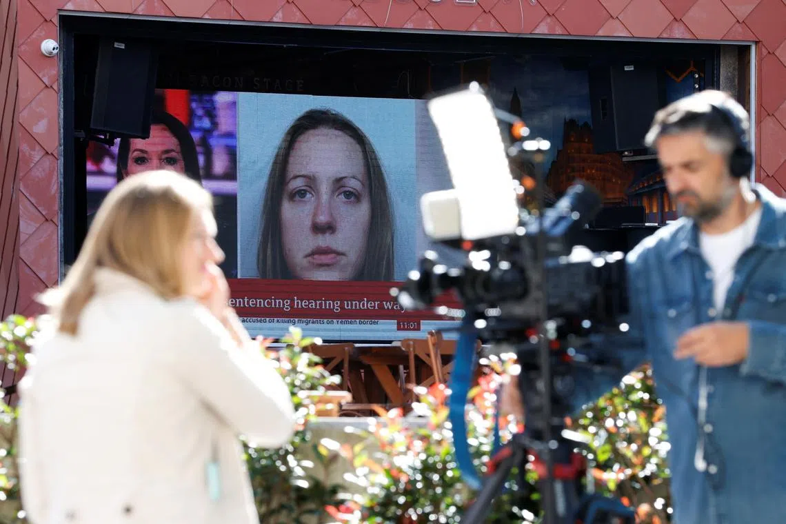 Members of the media work near a large screen showing a picture of convicted hospital nurse Lucy Letby, ahead of her sentencing, outside the Manchester Crown Court, in Manchester, Britain, August 21, 2023. REUTERS/Phil Noble/ File Photo