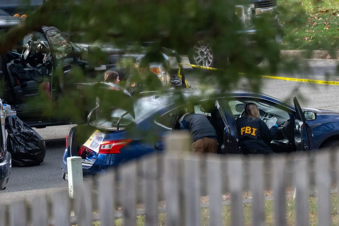 Law enforcement officials examine a vehicle in front of the home of a suspected Capitol pipe bomber.