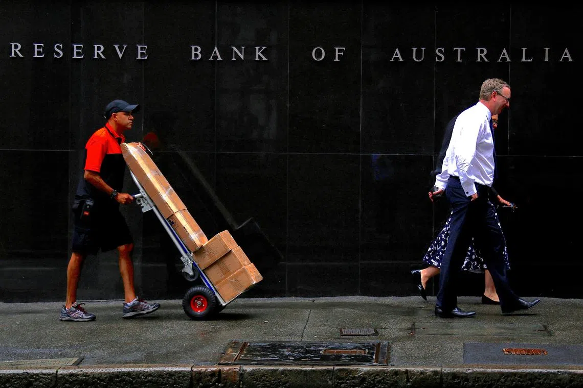 FILE PHOTO: A worker pushing a trolley walks with pedestrians past the Reserve Bank of Australia (RBA) head office in central Sydney, Australia, March 7, 2017. Picture taken March 7, 2017.   REUTERS/David Gray/File Photo
