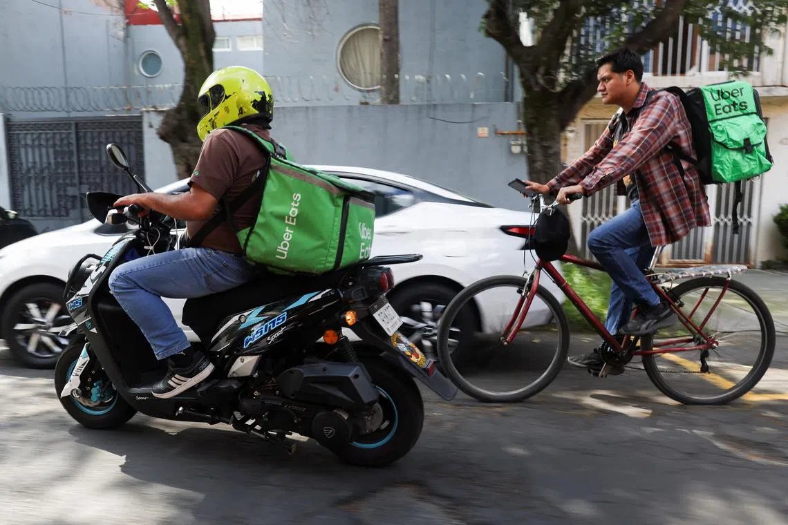Delivery drivers for Uber Eats transport food orders as Mexico proposes a labor reform for drivers and delivery workers using applications like Uber, Didi and Rappi, officials said on Wednesday, in Mexico City, Mexico October 16, 2024. REUTERS/Gustavo Graf/File Photo