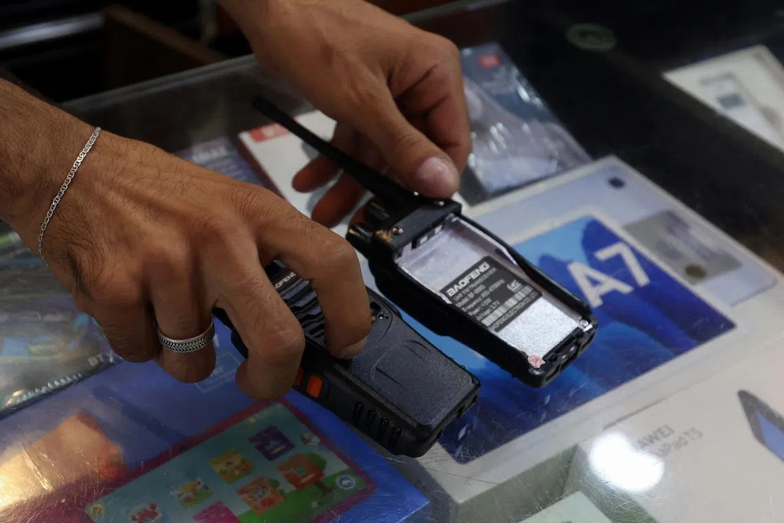 FILE PHOTO: A vendor shows walkie-talkie devices without batteries, which he says he removed for safety reasons at an electronic store in Sidon, after hand-held radios used by Hezbollah detonated on Wednesday across Lebanon's south and in Beirut's southern suburbs, Lebanon September 18, 2024. REUTERS/Aziz Taher/File Photo